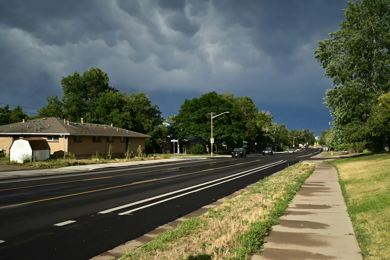 Roof Replacement in Milford — storm clouds gathering over a suburban street